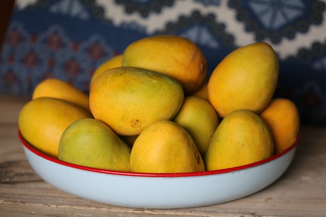 Mangoes waiting to be sorted on a plate.